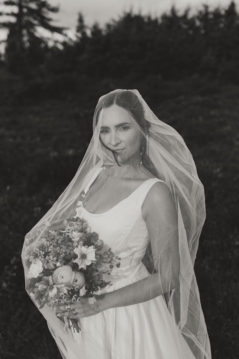 bride under veil with bouquet at wedding in pei