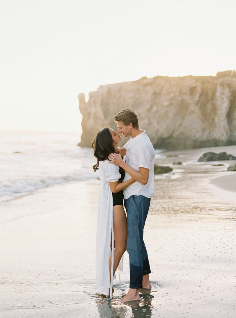 Engaged couple holding each other in Malibu