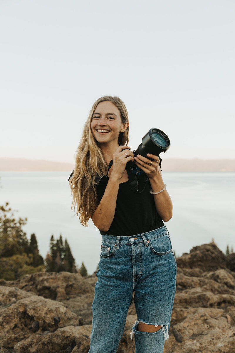 California elopement photographer Kasey Mantiply holding camera and laughing