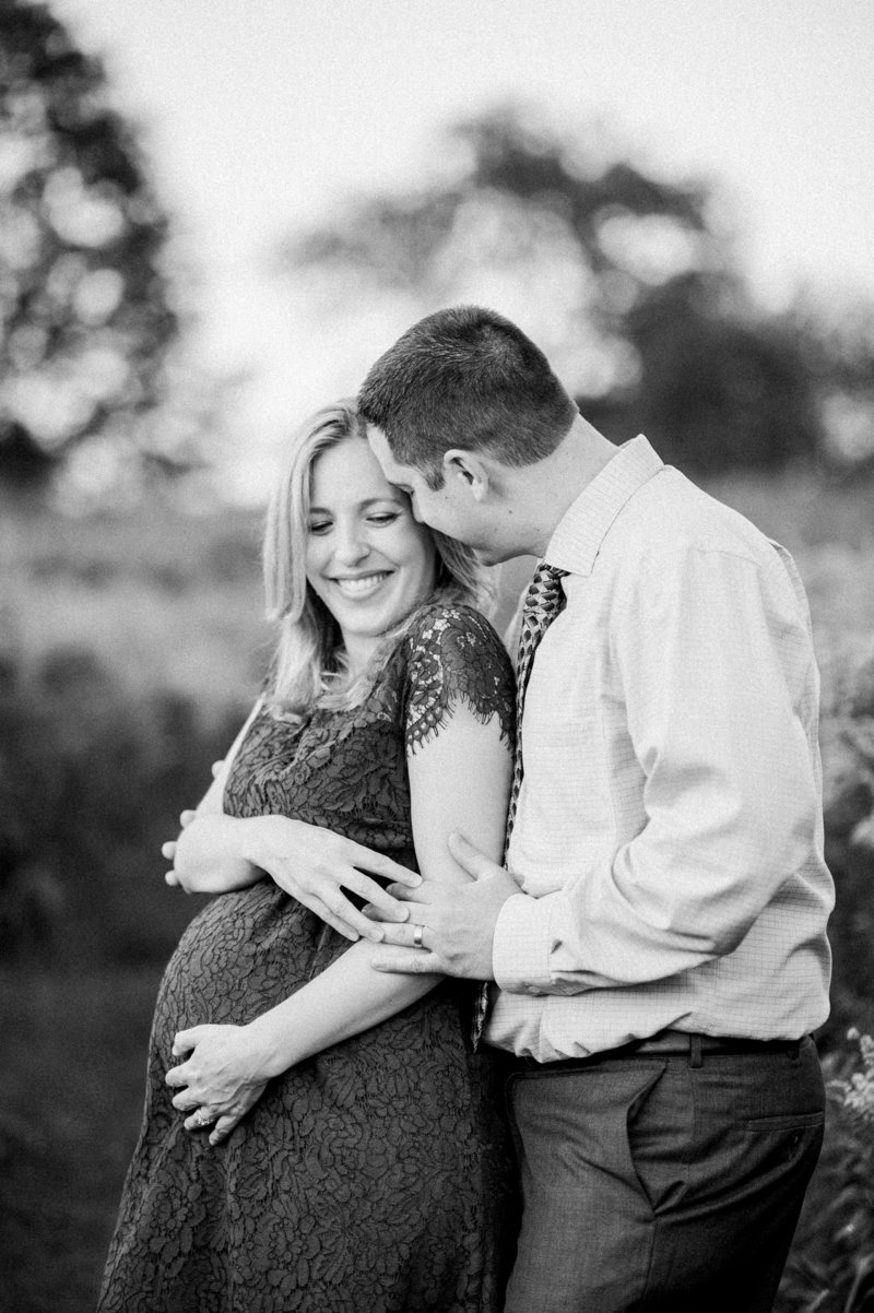 black and white maternity photo of couple in a field by carrie pellerin
