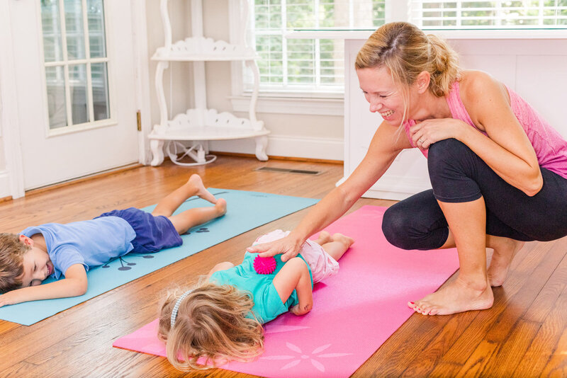 kids yoga teacher working with kids laying on a mat