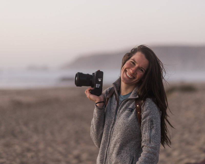 woman holding a camera while smiling