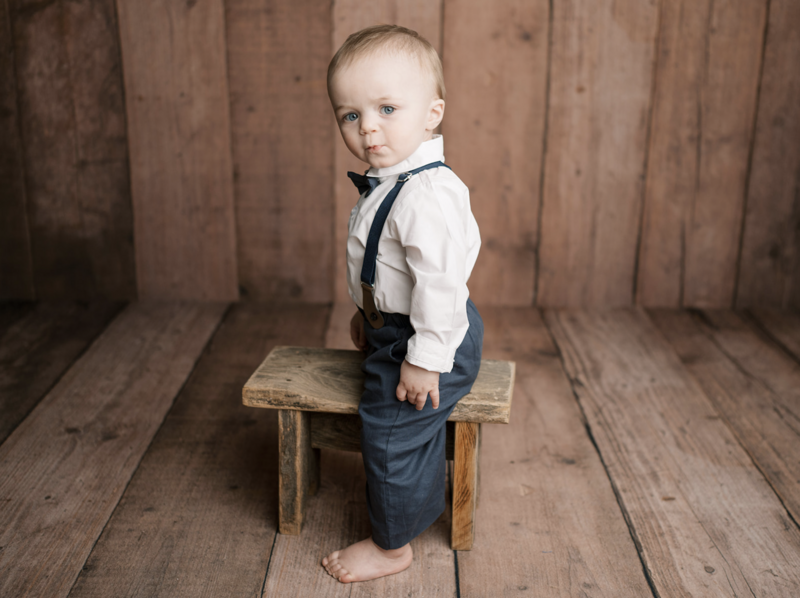 Little boy in suspenders and bow tie looking at the camera