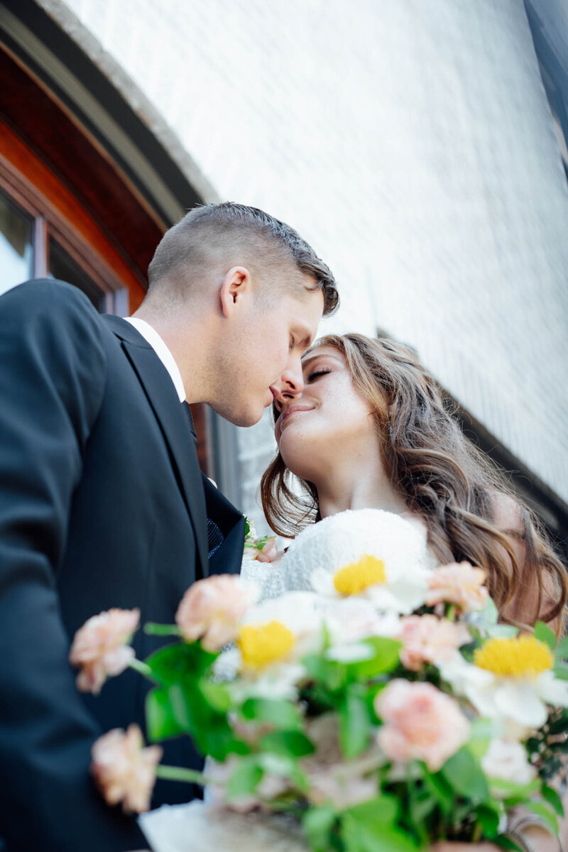 Couple almost kissing with bouquet