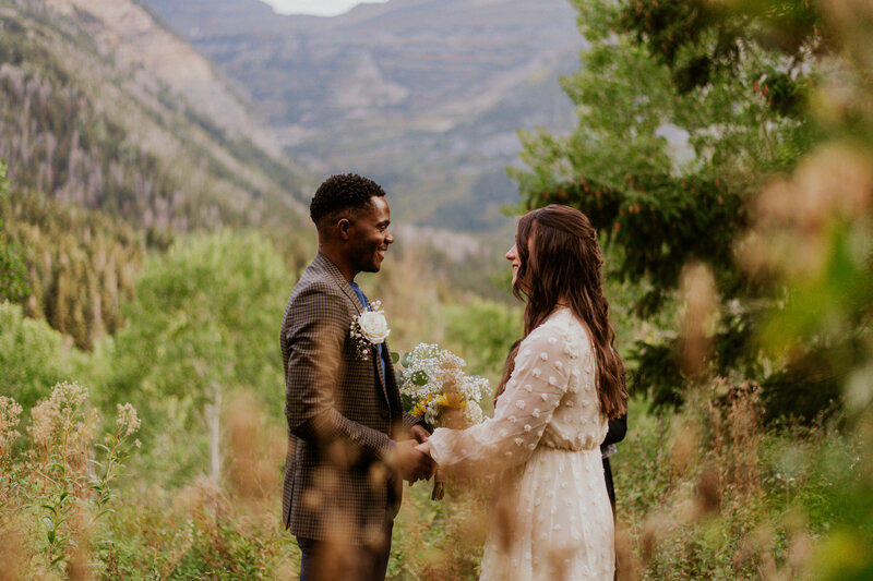 Couple at a field at the base of the Grand Teton mountains right after the proposal