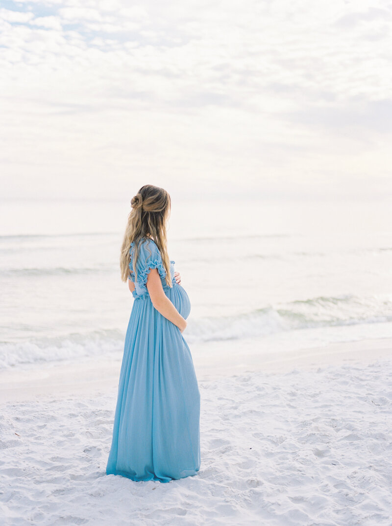 expecting mother gazing at ocean from Florida maternity photographer