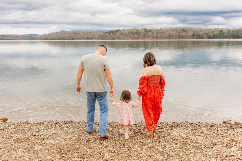 parents walking with their child by the lake