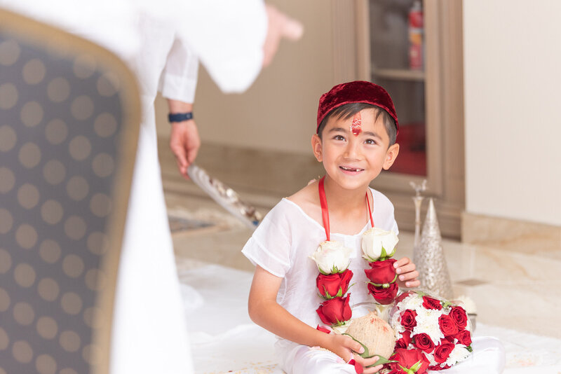 A boy smiling at his Navjote ceremony.
