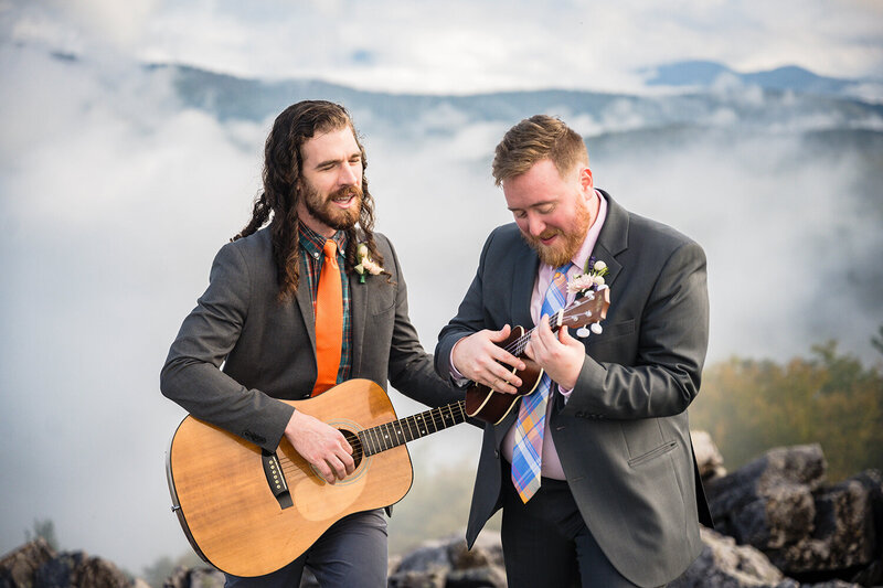 A gay couple sings as they play their instruments atop of a large rock pile at Blackrock Summit in Shenandoah National Park.
