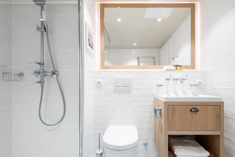 Badezimmer mit Dusche, WC und Waschbecken in einer Juniorsuite.