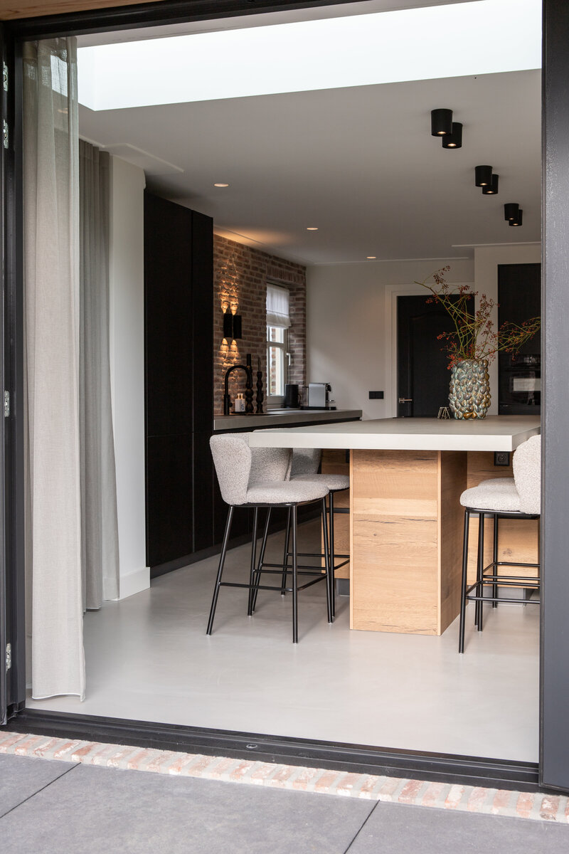 Een ruime leefkeuken ontworpen door Chrissy Interiors. Met een combinatie van landelijke en moderne elementen biedt deze keuken de perfecte ruimte om te ontspannen en te socializen met familie en vrienden.
