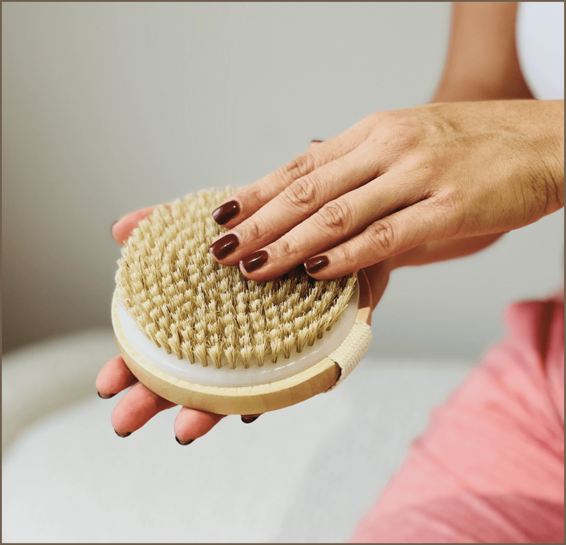 Hands holding a dry body brush