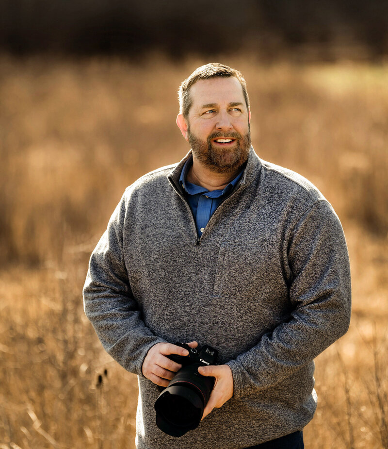 Scott Shaw holds a camera as he photographs in a field near Cleveland.