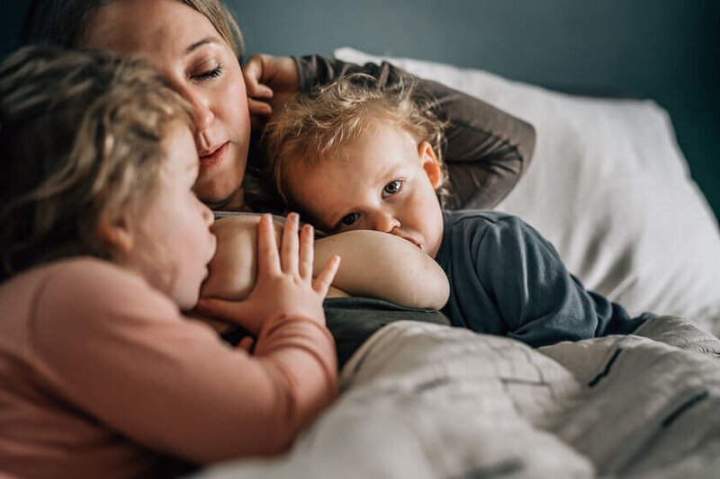 Nursing photo session with mom tandem breastfeeding two toddlers by Minnesota photographer Kate Simpson.