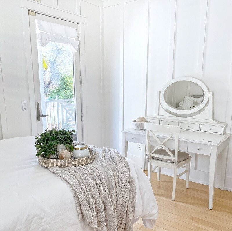 girls bedroom with board and batten sherwin williams pure white and vanity with mirror and queen size bed with a pathos plant