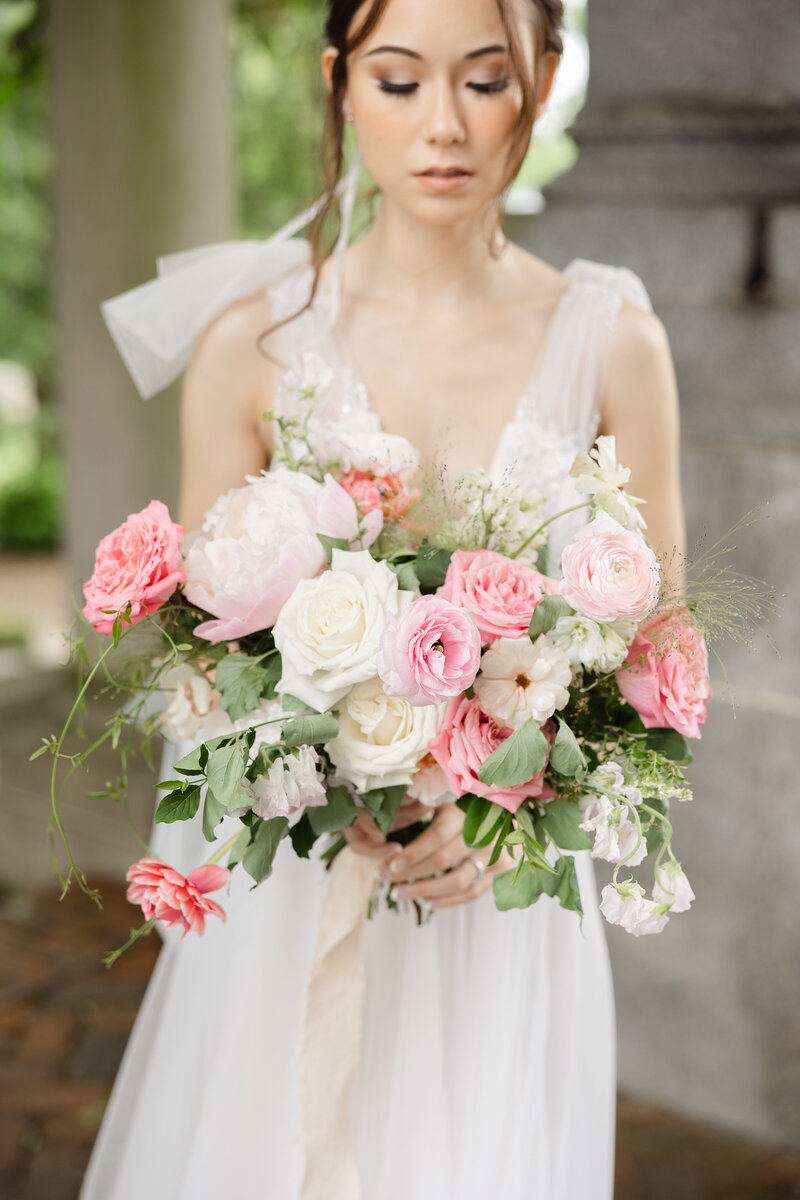 close up photo of bride holding pink wedding bouquet