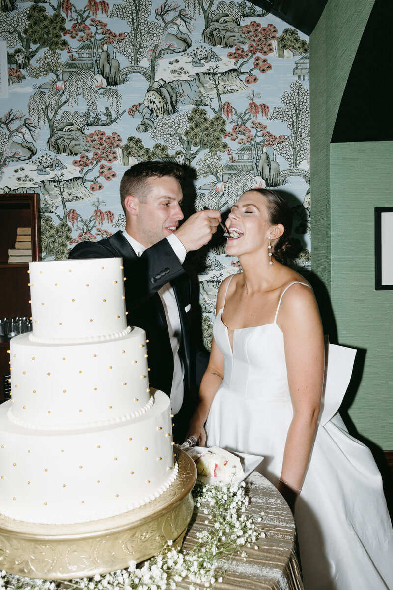 Bride and groom feeding each other cake during their reception, captured by a Madison wedding photographer.