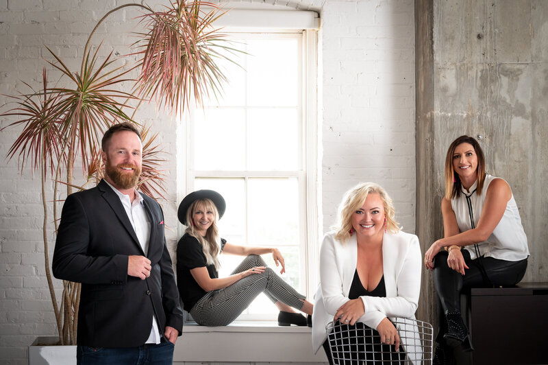 Elegant Salt Lake City real estate team posed in a high-end interior space, reflecting a polished and upscale brand presence.