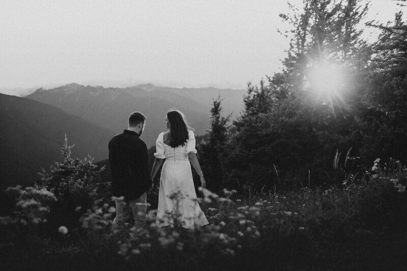 black and white image couple holding hands in forest