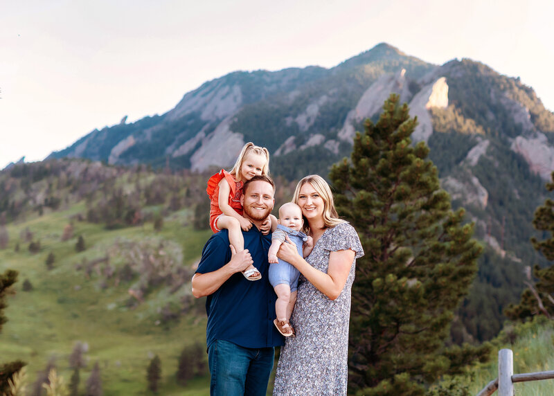boulder family of 4 enjoying a playful moment during their summer photoshoot in front of the flat irons in boulder colorado