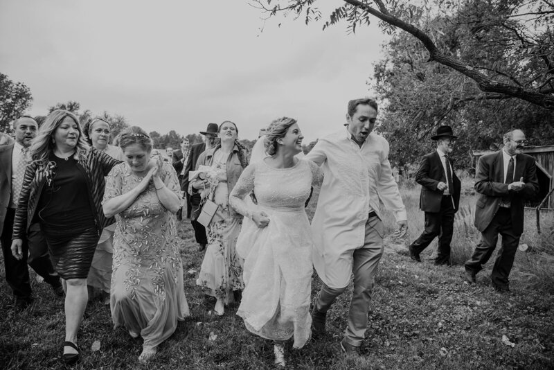 A couple dances away from their ceremony with family celebrating their marriage