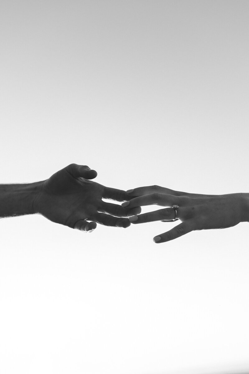 hands touching with engagement ring on the females married finger