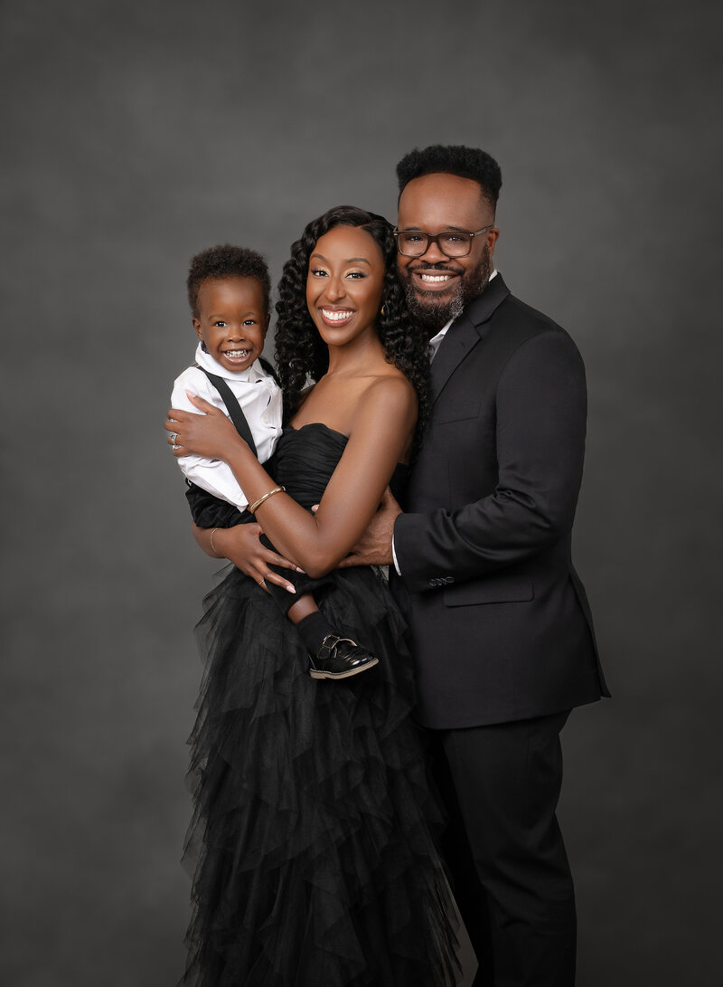 Family formal portrait in studio with black backdrop and formal attire. Jenni Nikki Photography takes formal family portraits at her Atlanta photo studio.