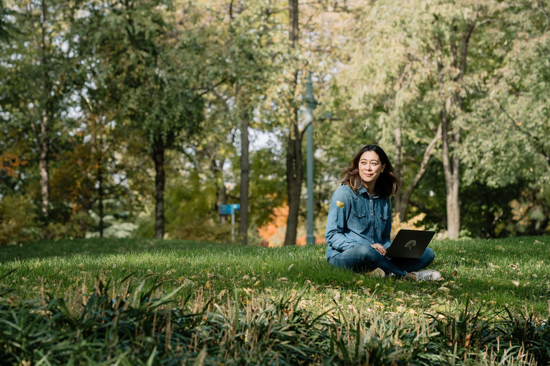 Danielle sitting peacefully in a grass field, inviting you to explore your wellness journey through a Discovery Session.