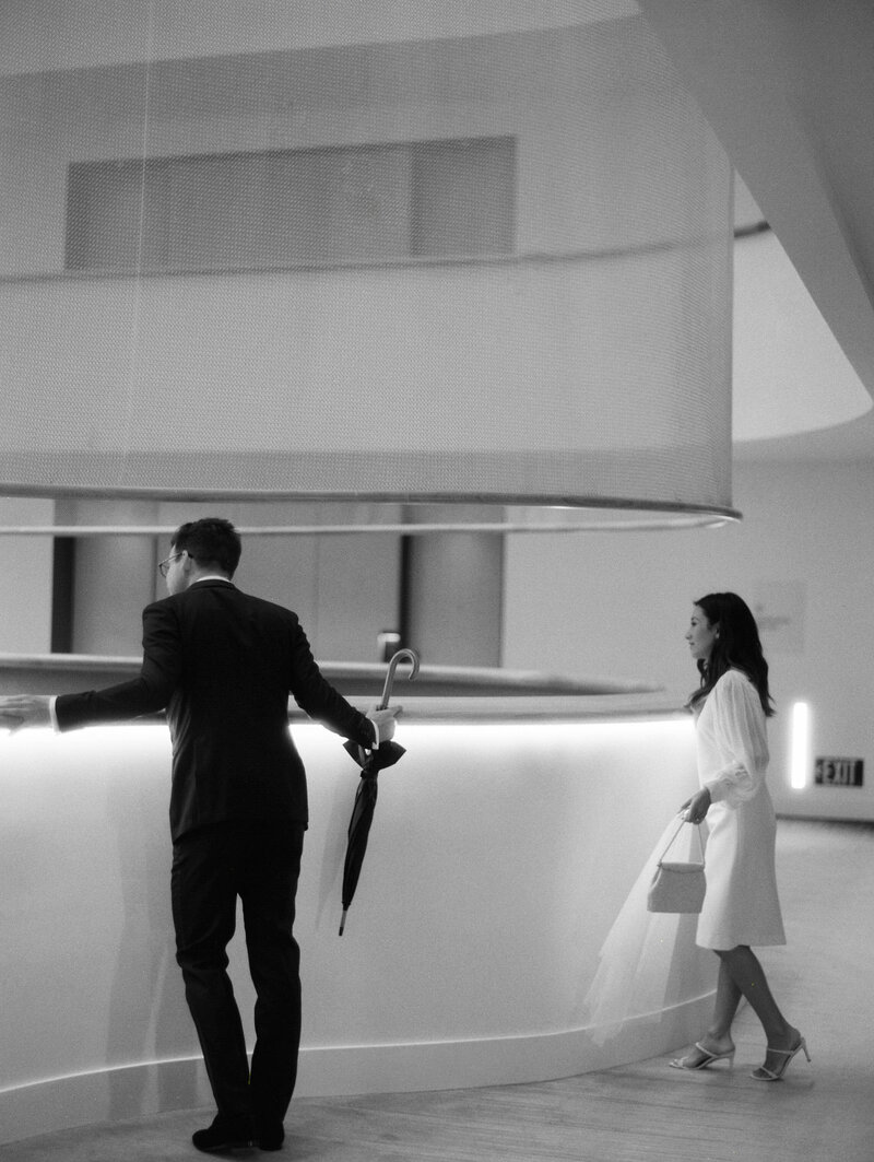 Bride and groom looking down over hotel lobby