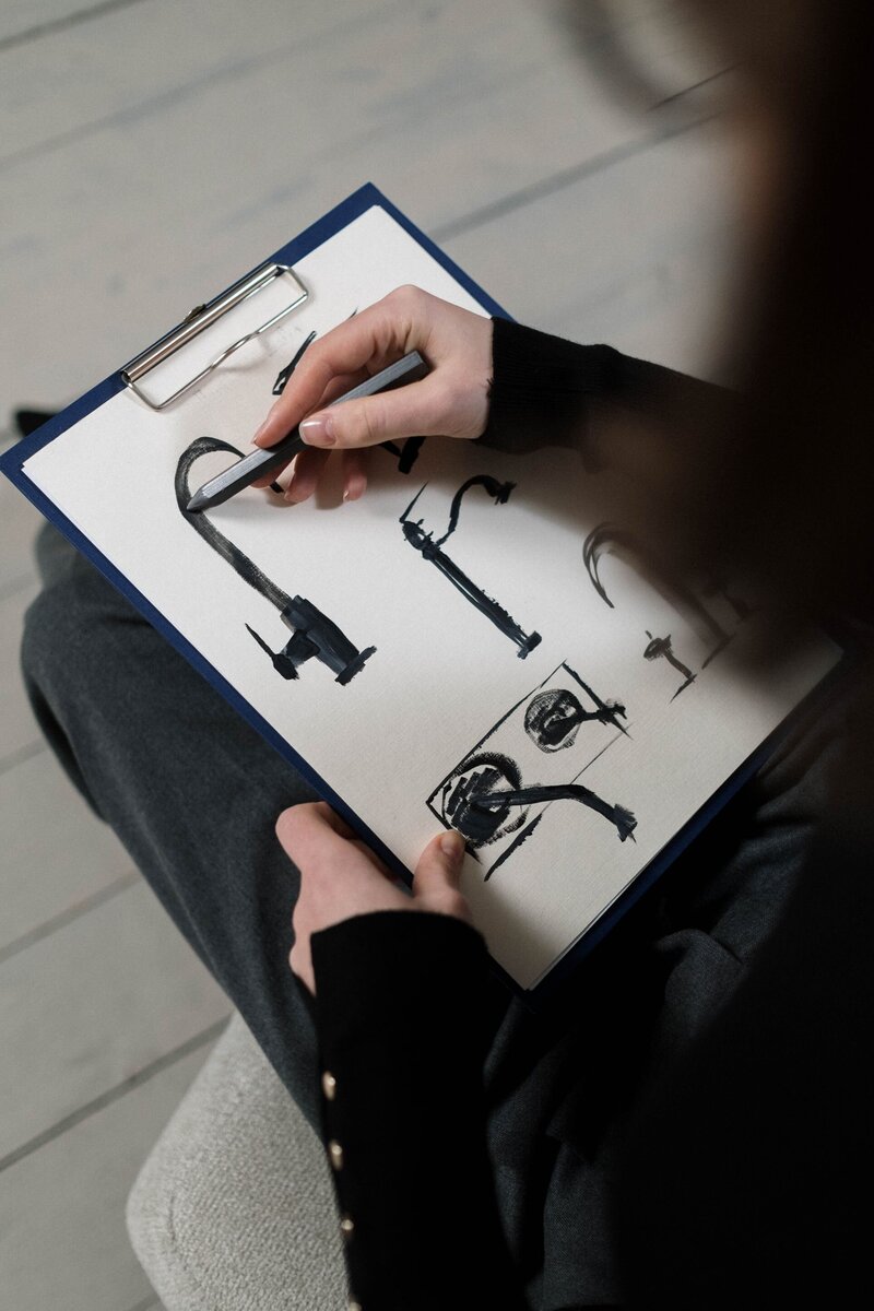 Women with clipboard sketching taps