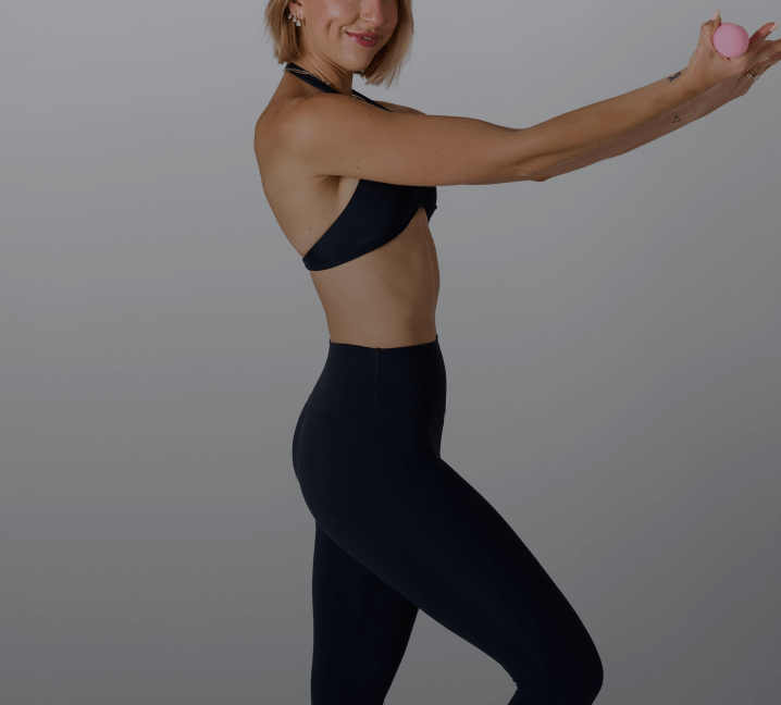 Women holding weights with her arms in a black athleisure set