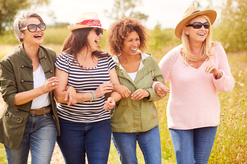 Woman smiling in nature, reflecting confidence, radiance, and the vibrant life available after 45