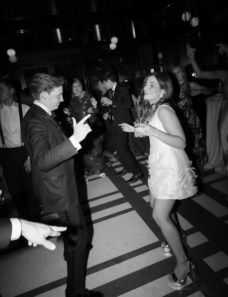 bride in short reception dress, second look with flower detail, silver mirror pumps, dances with her husband at Shinola Hotel Detroit wedding