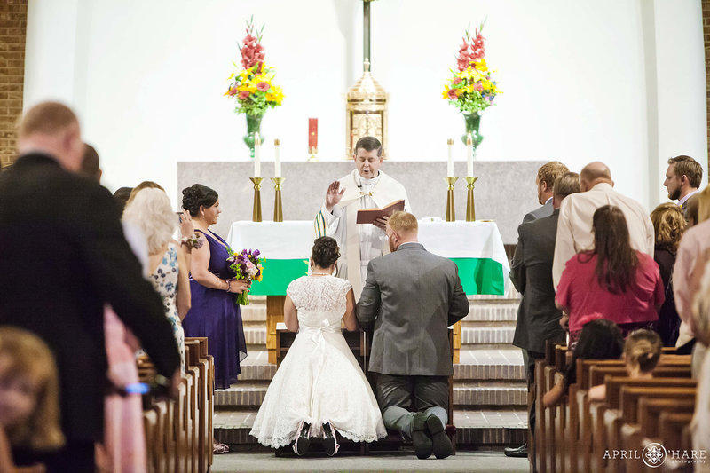 Couple kneels before altar on their wedding day at St. Mary Catholic Church in Greeley