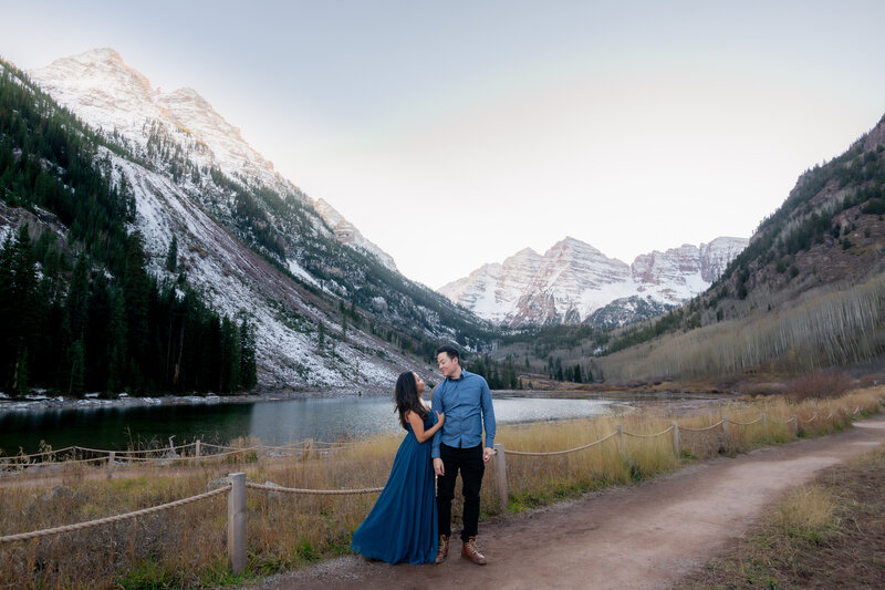 Colorado Maroon Bells elopement with bride and groom in blue overlooking mountains and lake during sunset.