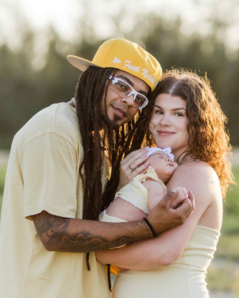 Mom and dad hug infant daughter