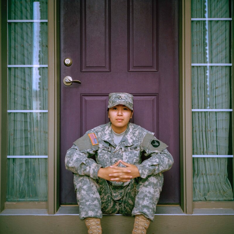 Woman in military uniform sitting on steps