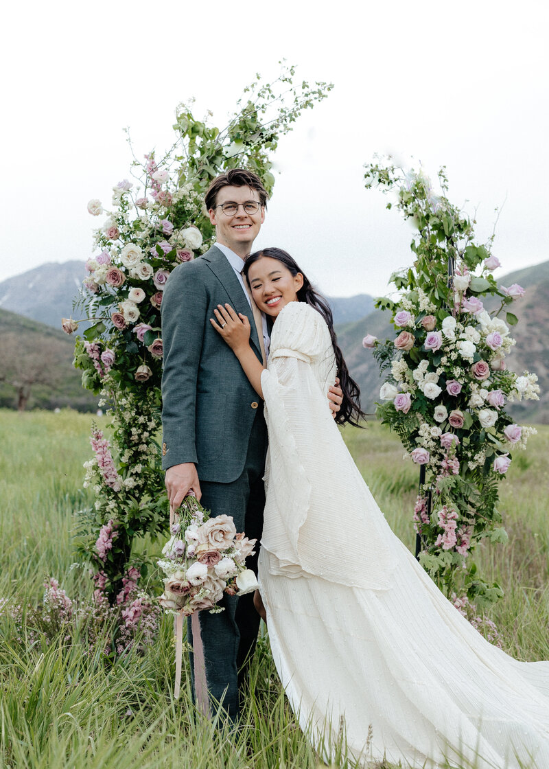 Wedding Photographer, couple standing in between two floral arches