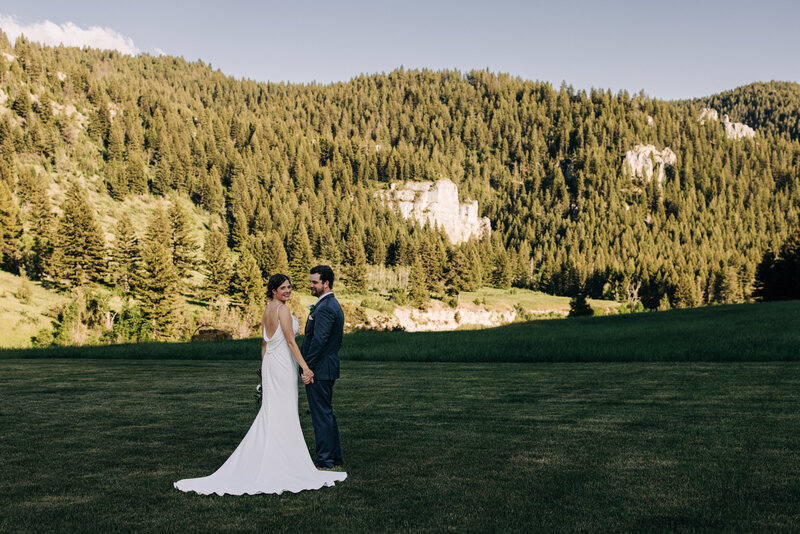 Bride and Groom in field with mountain backdrop