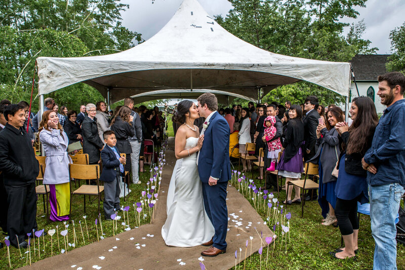 bride and groom kiss as guests look on
