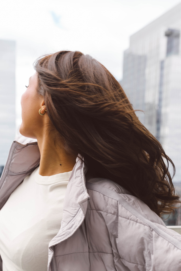 Women with dark brown hair looking behind her at the Chicago skyline