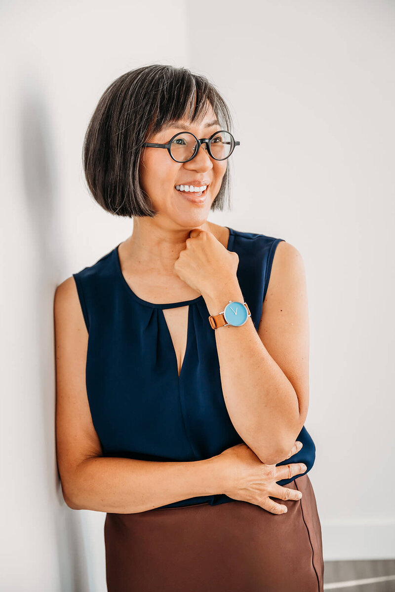 woman standing against the wall in a blue shirt