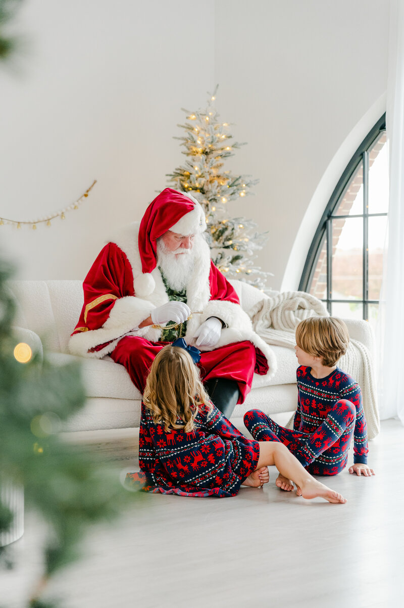 Young kids turning to find Santa behind them at Santa experience in North Atlanta Studio