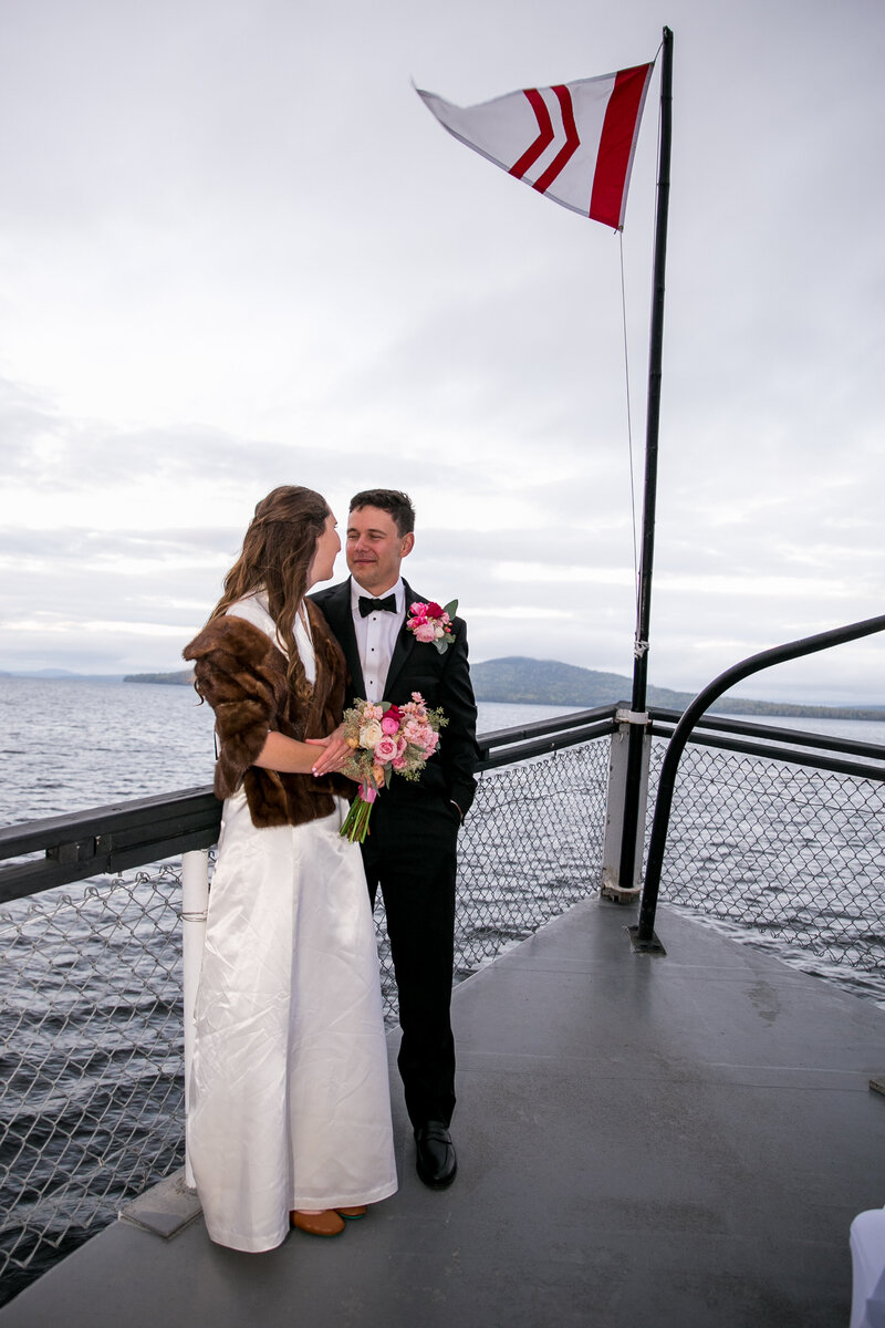 Bride and Groom standing at front of boat looking at each other | Wedding Photography