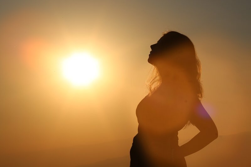 Image of a woman standing in the sun looking up