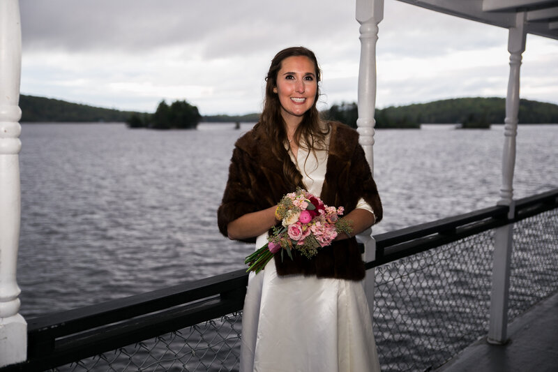 Bride standing on boat with flowers | Wedding Photography