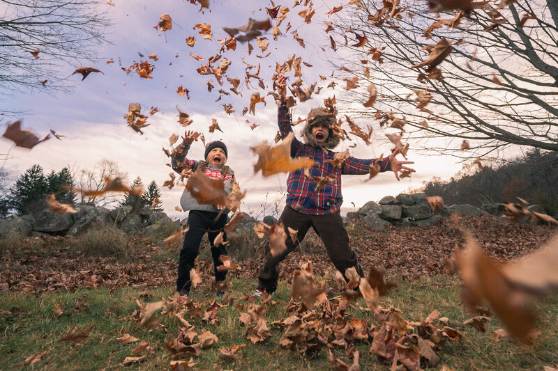 Siblings throwing leaves in the air