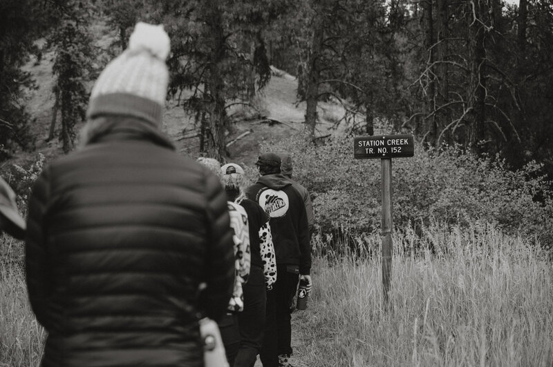 A group of people hiking outdoors with their back to the camera, representing adventure based counseling in boise idaho.