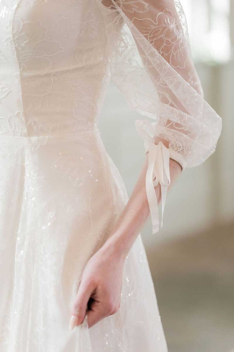 bow details on wedding dress with hand lace sleeves - timeless bridal designer in Charleston, SC