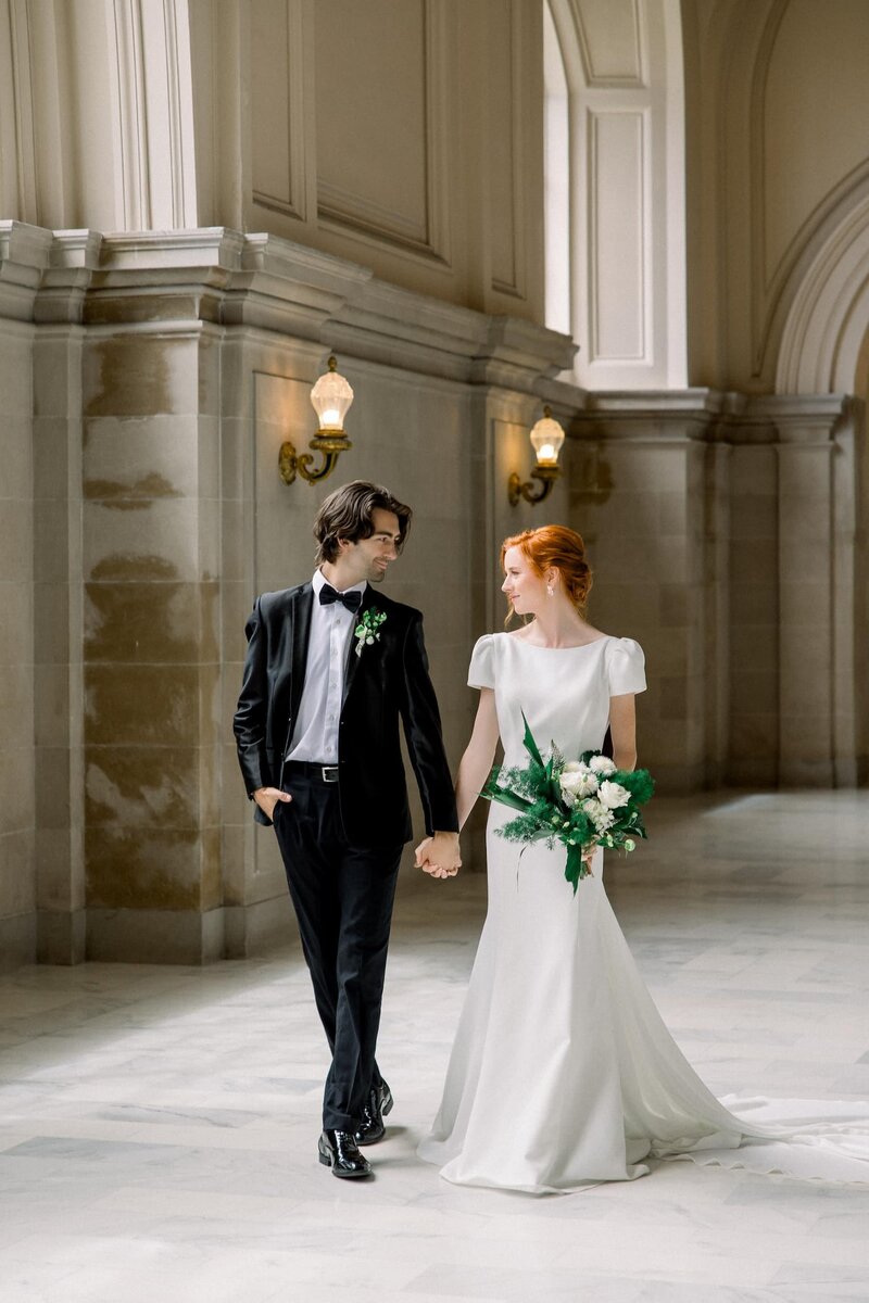 Bride and groom walking San Francisco city hall